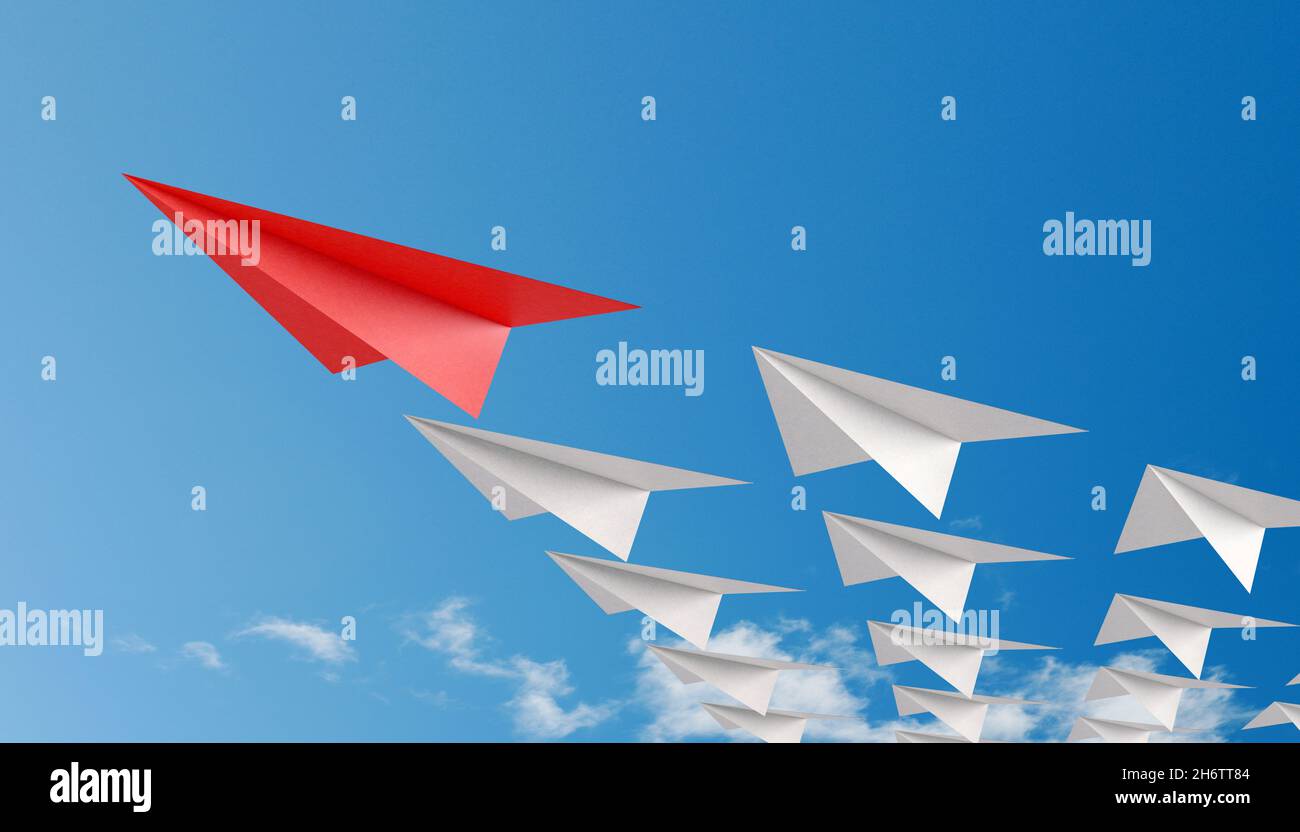 Red paper plane as leader of others on a  blue background with clouds Stock Photo