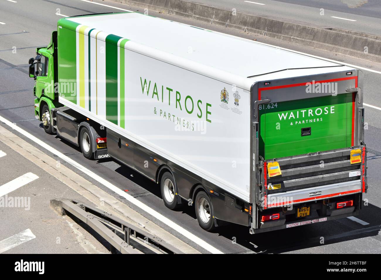 Aerial side & back view of Waitrose retail online business supermarket food supply chain store delivery lorry truck & trailer driving on UK motorway Stock Photo