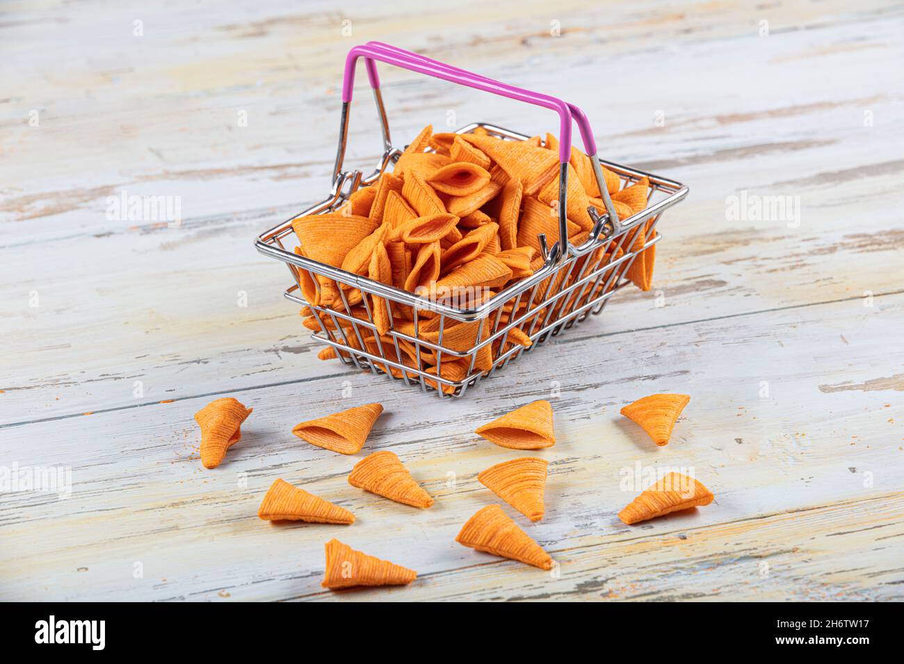 Portion of cone shaped snack tornado shaped crackers. Yellow spicy