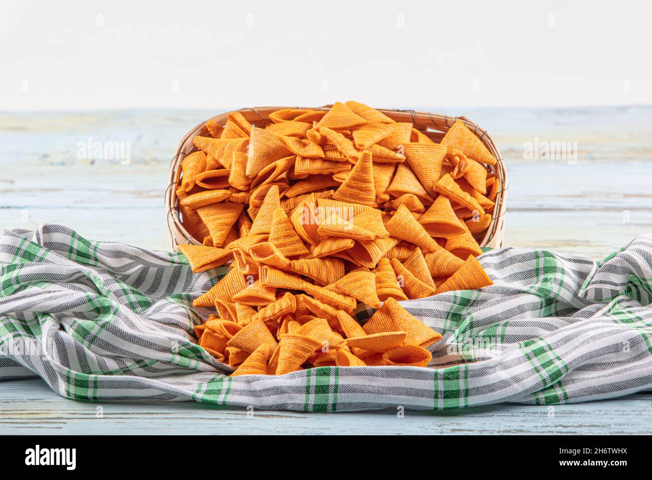 Portion of cone shaped snack tornado shaped crackers. Yellow spicy