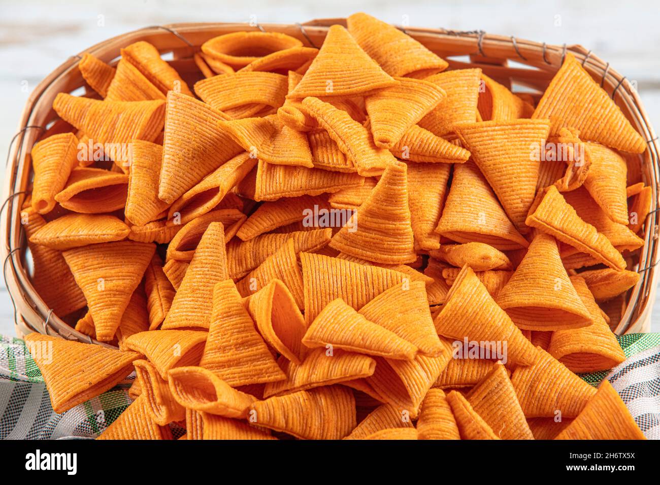 Portion of cone shaped snack tornado shaped crackers. Yellow spicy potato cone chips texture or Background of corn cone. Stock Photo