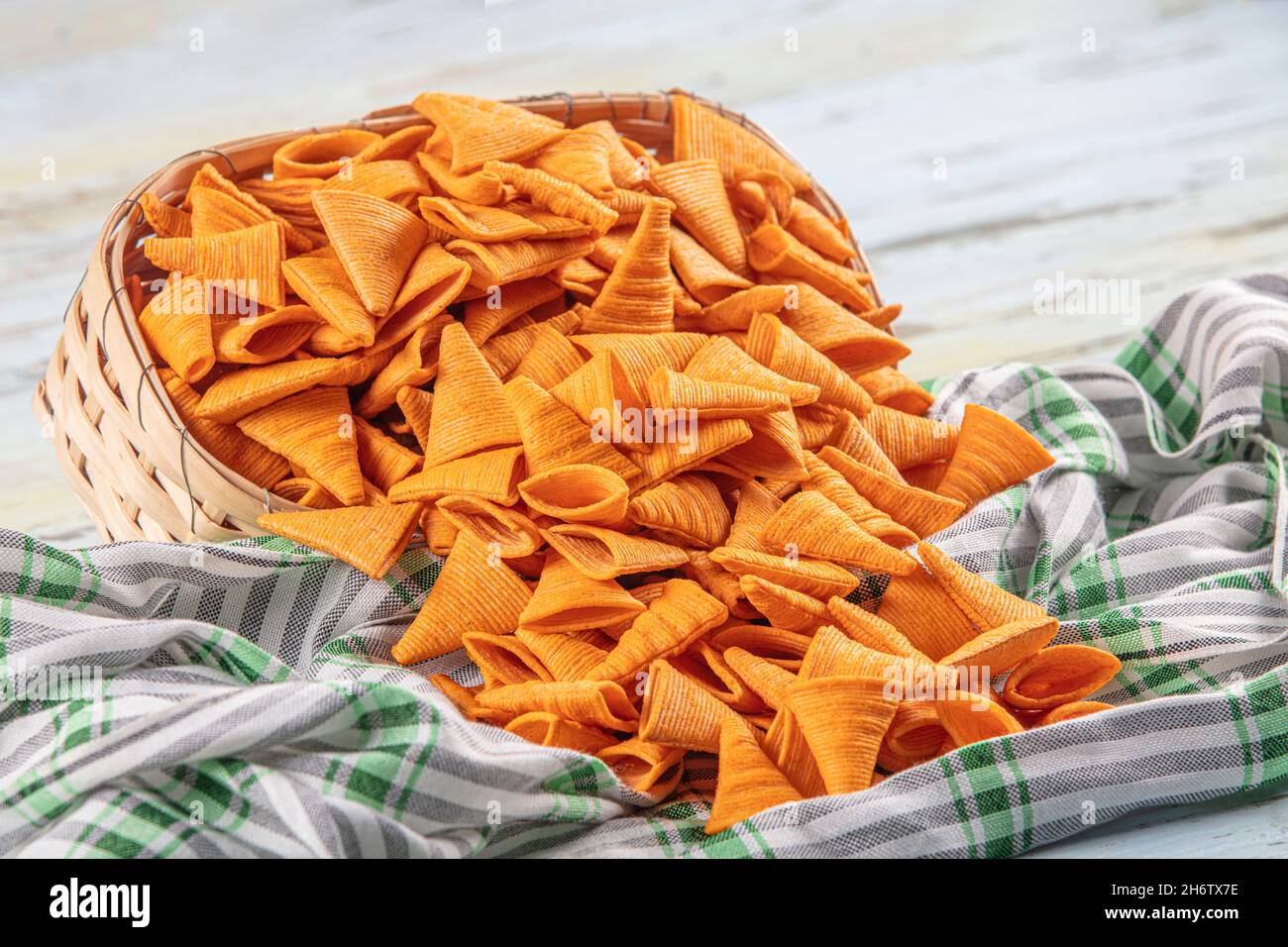 Portion of cone shaped snack tornado shaped crackers. Yellow spicy