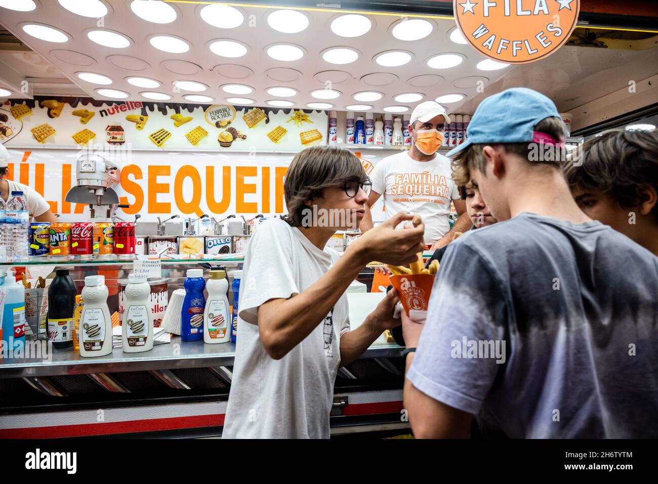Faro, Portugal - October 22, 2021: Group of teenagers eating sweet churros at Santa Iria Festival Stock Photo