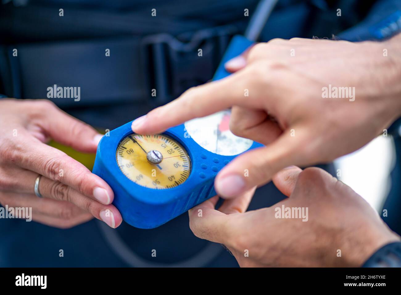 Man explaining that pressure gauge shows how much air is in the tank during scuba diving, Spain Stock Photo
