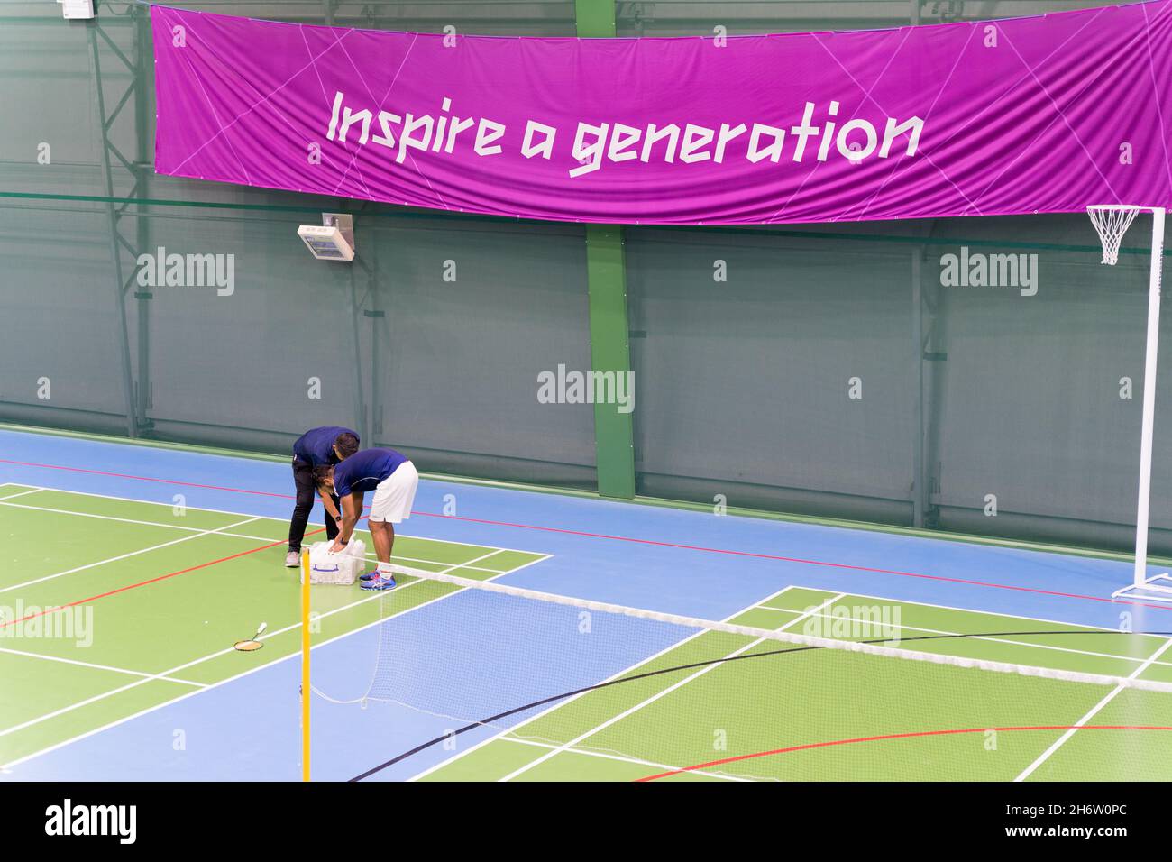 two players pick up shuttlecocks on badminton court at a badminton