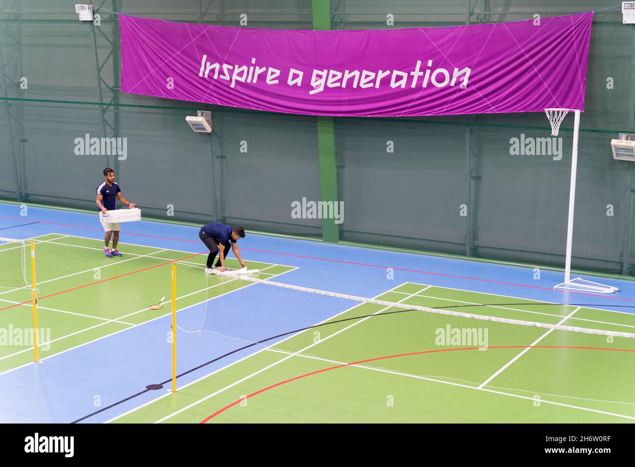 two players pick up shuttlecocks on badminton court at a badminton