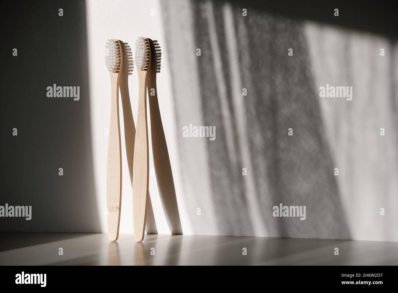 two light wood bamboo eco recyclable toothbrushes standing vertical ...