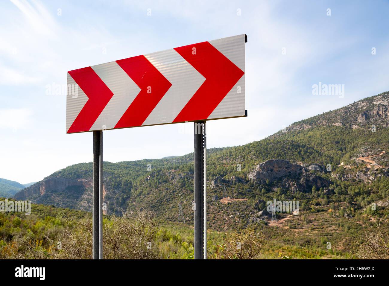 Dangerous bend direction sign. Dangerous bend direction sign placed on ...