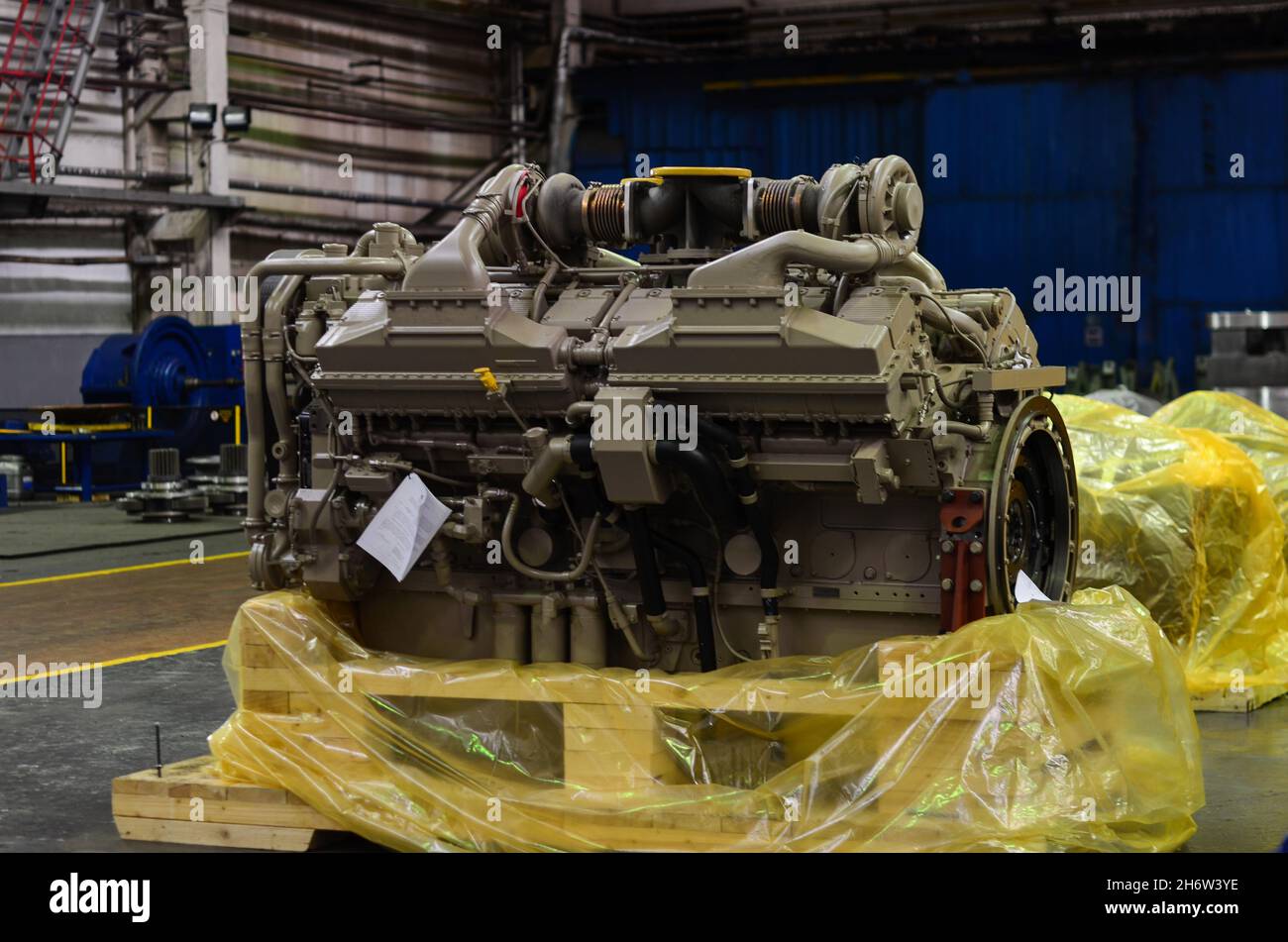 Large diesel engine with a huge turbine in the warehouse of finished ...