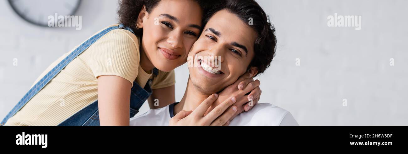smiling african american woman hugging boyfriend at home, banner Stock ...
