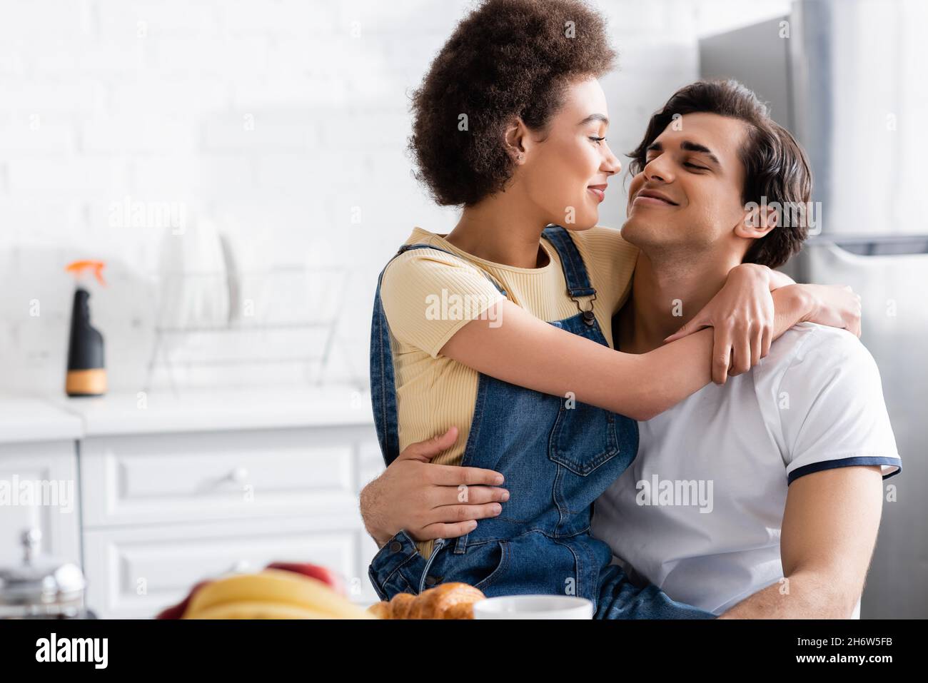 happy african american woman hugging boyfriend in kitchen Stock Photo ...