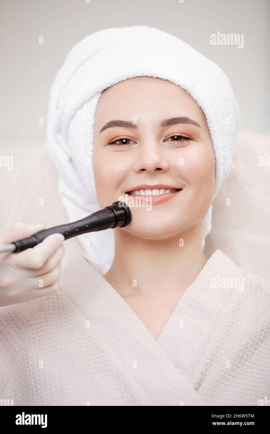 Closeup microcurrent procedure for lifting skin face treatment young