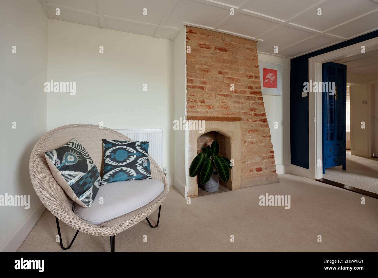 Wixoe, England - September 26 2019: Landing entrance hall with panelled ceiling, fireplace and chair Stock Photo