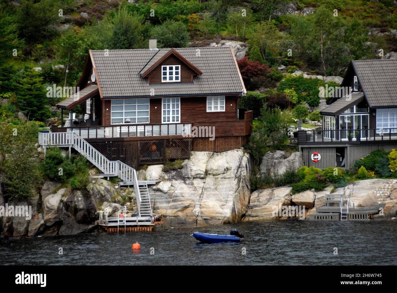 Waterside houses built well above the water level beside a Norwegian fjord Stock Photo