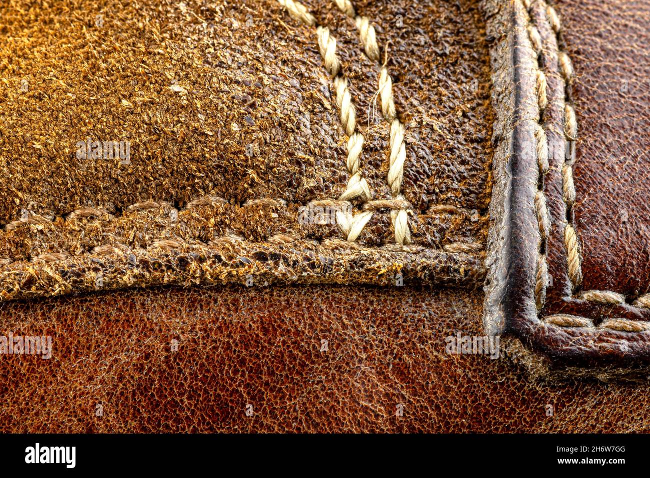 Macro background made of brown natural leather with white stitches all around. Stock Photo