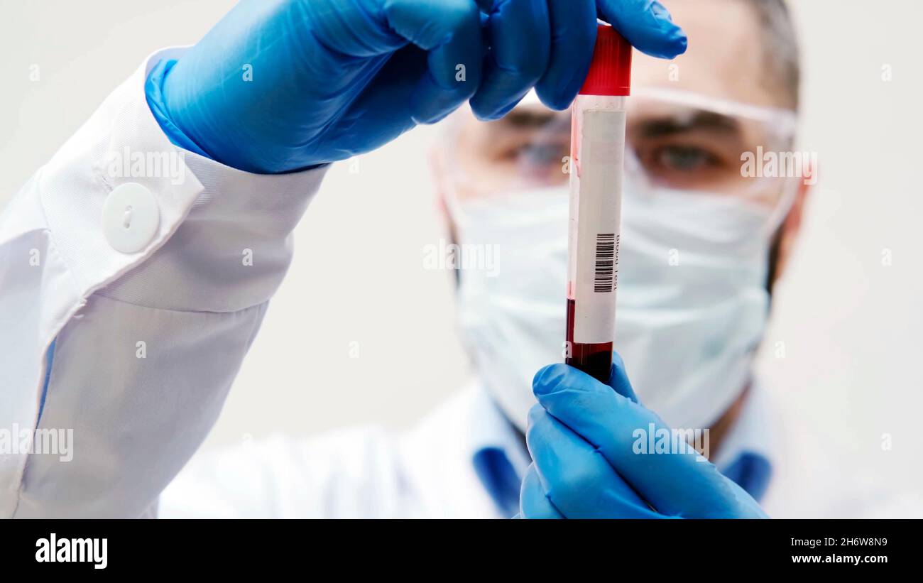 close-up of a doctor's hands grasping a blood vial Stock Photo