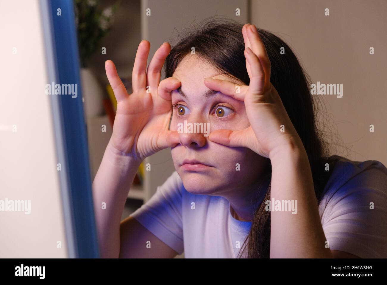 Face Into Computer The woman forces herself to look into the computer screen, opening her ...