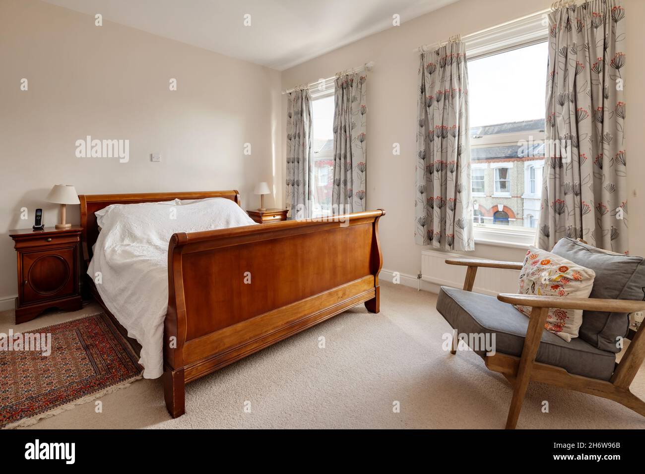 Cambridge, England - October 28 2019: Typical bedroom within British victorian era home with simple decor and traditional looking furniture. Stock Photo