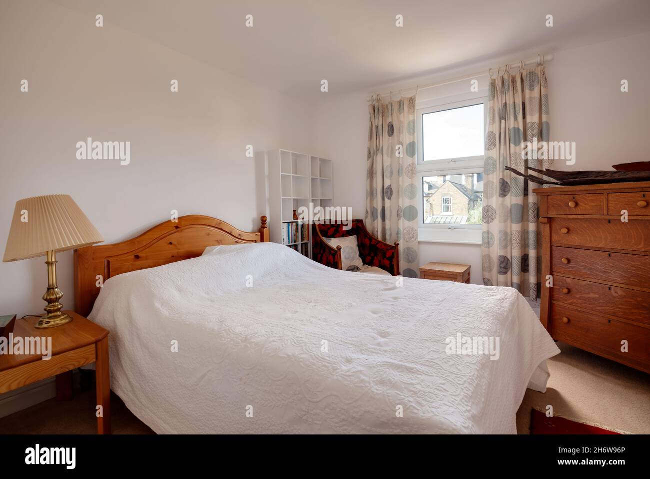 Cambridge, England - October 28 2019: Typical bedroom within British victorian era home with simple decor and traditional looking furniture Stock Photo