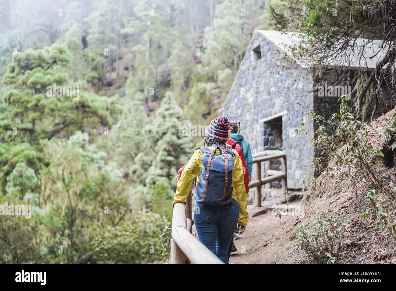 Multiracial women having fun exploring nature on trekking day into the woods - Focus on african woman back Stock Photo