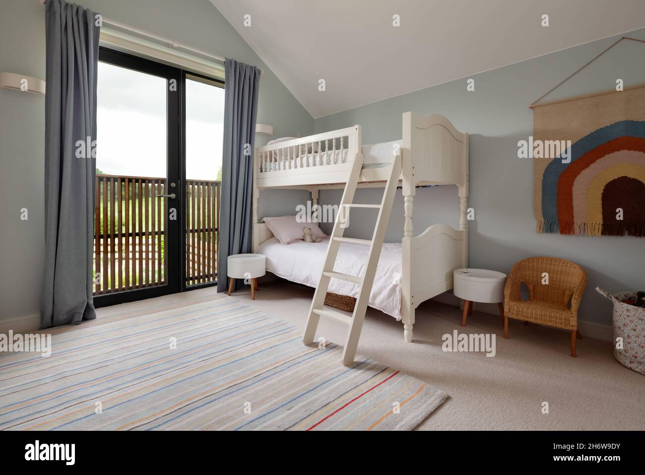 Dry Drayton, England - August 2 2019: Childs bedroom space with bunk bed including ladder decorated in blue and white Stock Photo