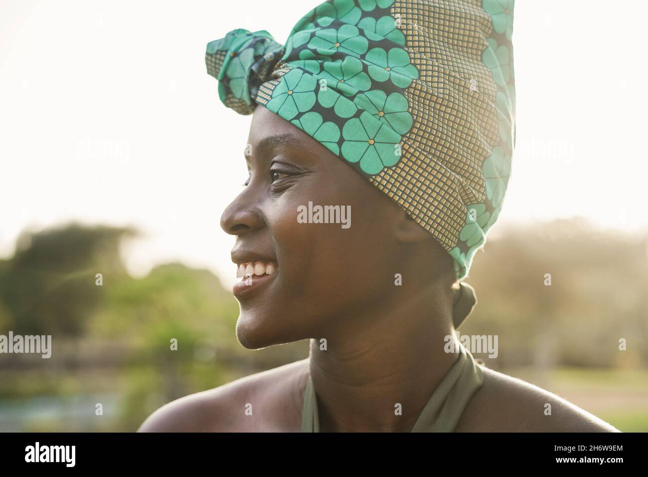 Portrait of african american woman smiling outdoor at city park - Focus ...