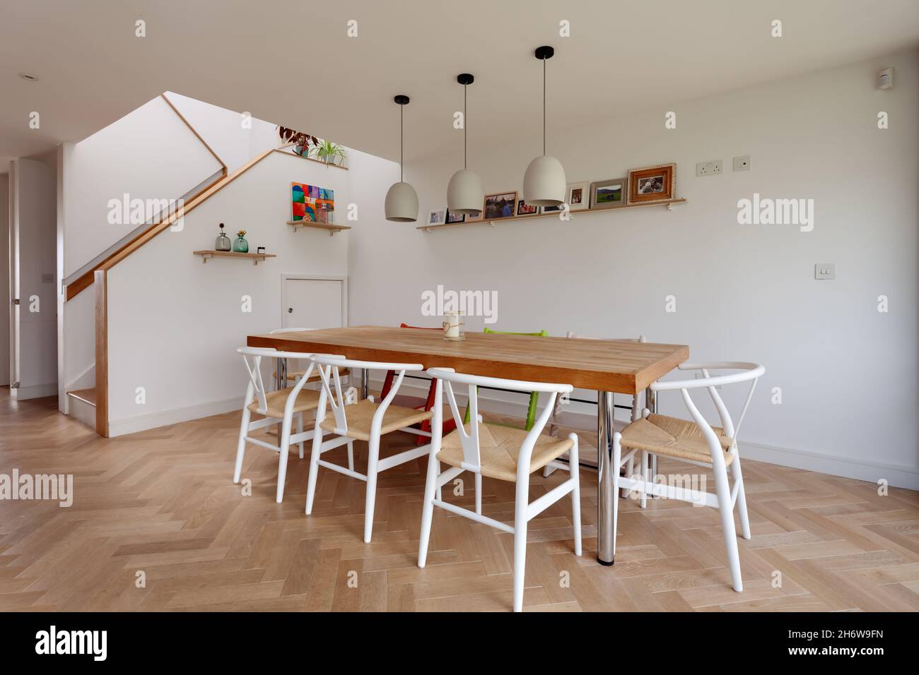 Dry Drayton, England - August 2 2019: Contemporary dining area with generously sized table, chairs and striking parquet floor. Stock Photo