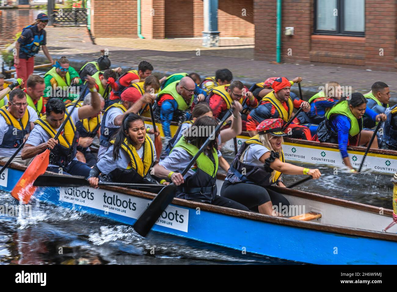 Dragon boat racing on Birmingham Canal Old Line at the Gas Street Basin in the heart of Birmingham. Regency Wharf is in the background. Stock Photo