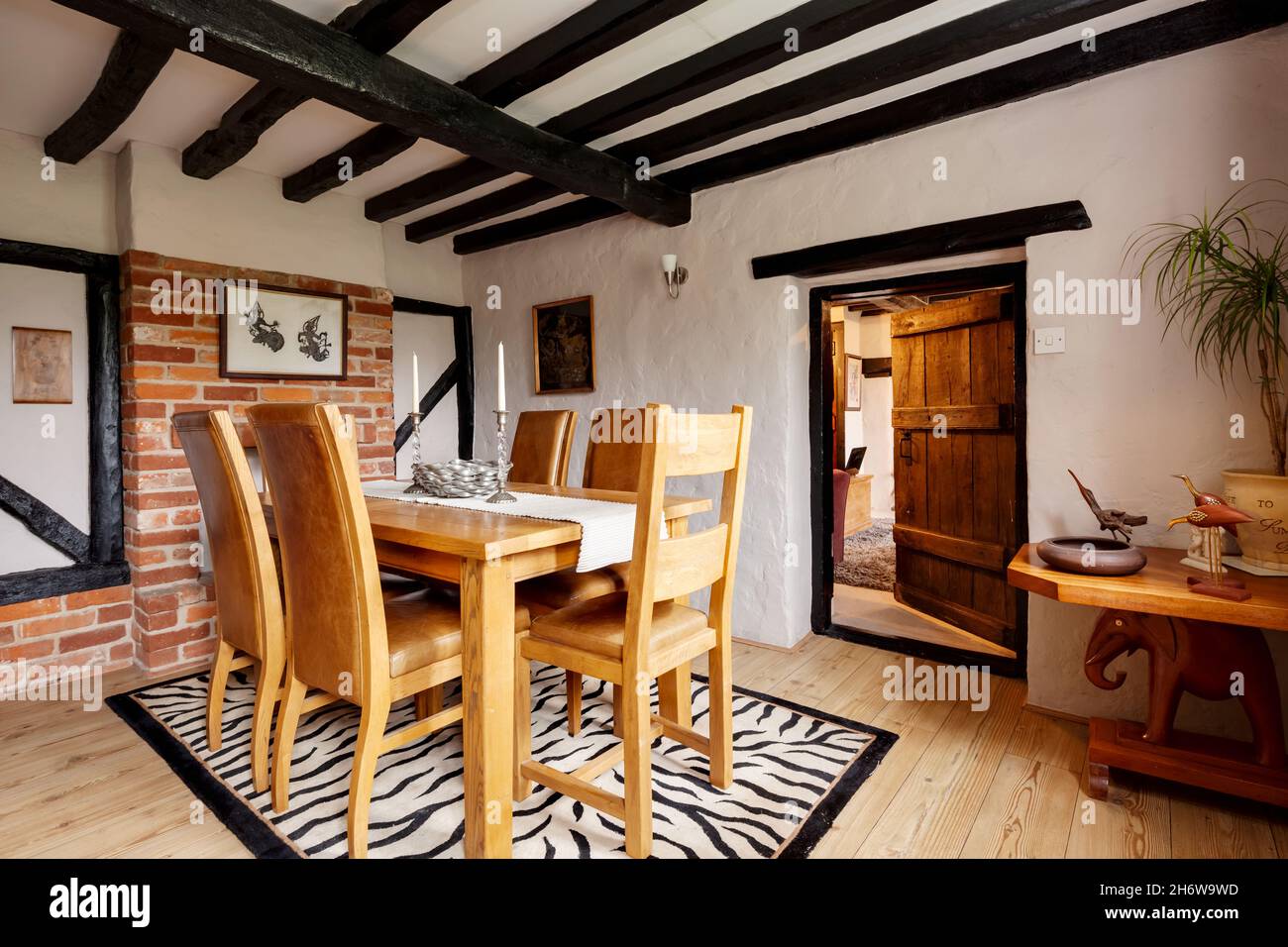 Kedington, Suffolk, November 19 2019: Cottage Dining room within traditional British cottage with oak dining table and chairs, exposed beam ceiling Stock Photo