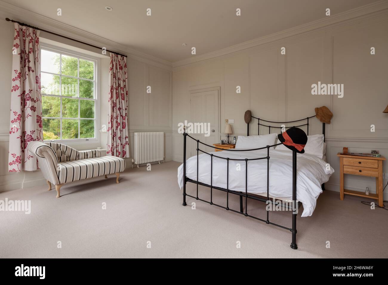 Wimbish, England - July 30 2019: Bedroom in English period home with   beautifully decorated and flooded with light from large sash window. Stock Photo