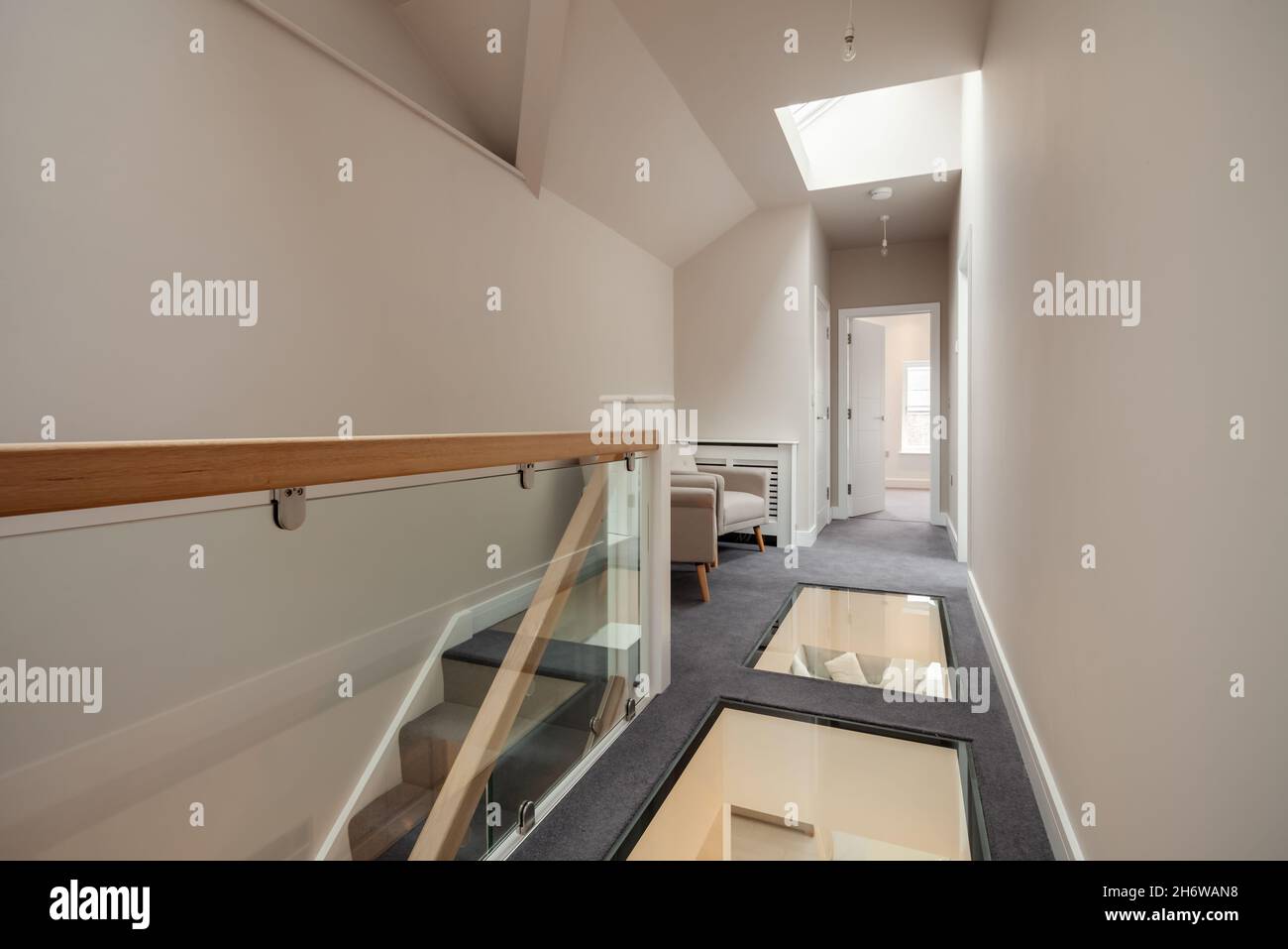Cambridge, England - August 16 2019: Modern first floor landing area in renovated vacant house with seating area and unusual glass floor Stock Photo