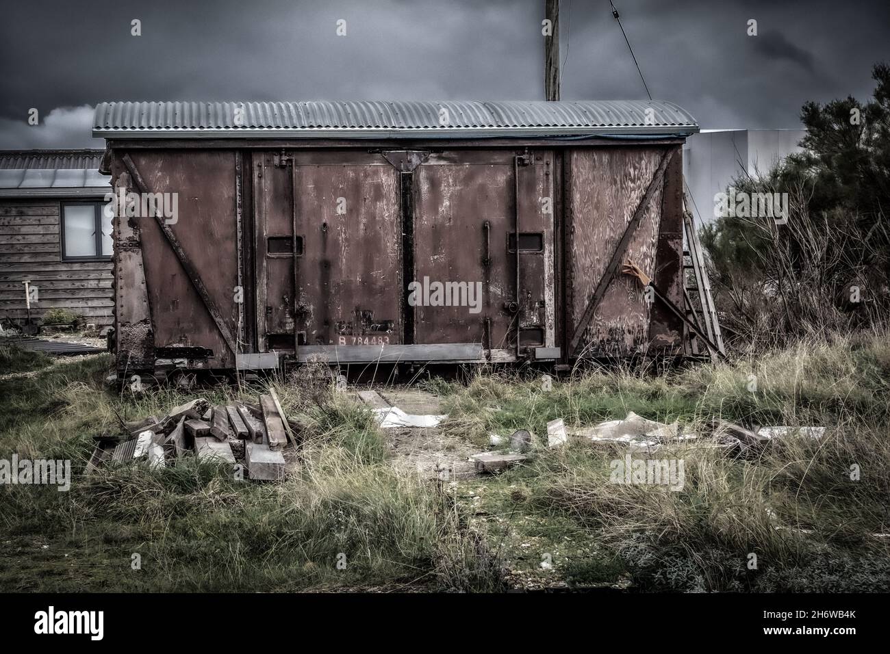 Wooden flaky rustic classic old vintage railway carriage in a moody and dark Filmic style, taken on the beach at Dungeness 14th of November 2021 Stock Photo