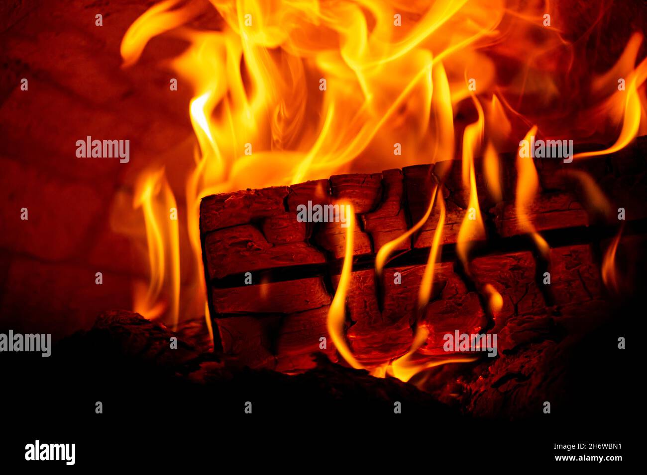 Burning log of wood in a fireplace closeup in a Barbecue Stock Photo