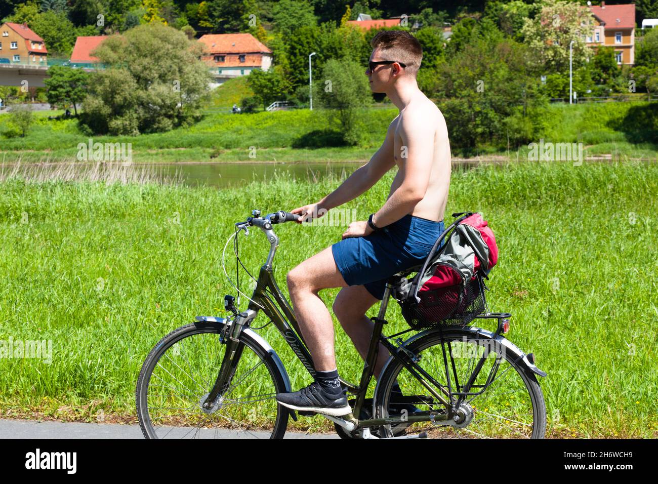 Young man riding a bicycle in summer Germany biker cycling Stock Photo
