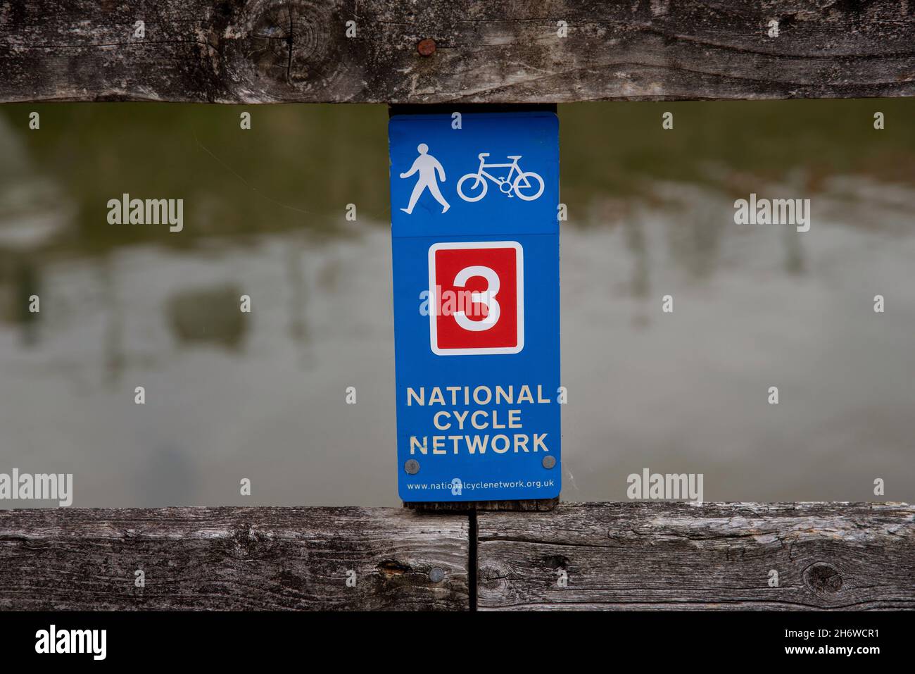 Cornwall, England, UK. 2021.  National cycle network marker sign on a fence above a river. Stock Photo