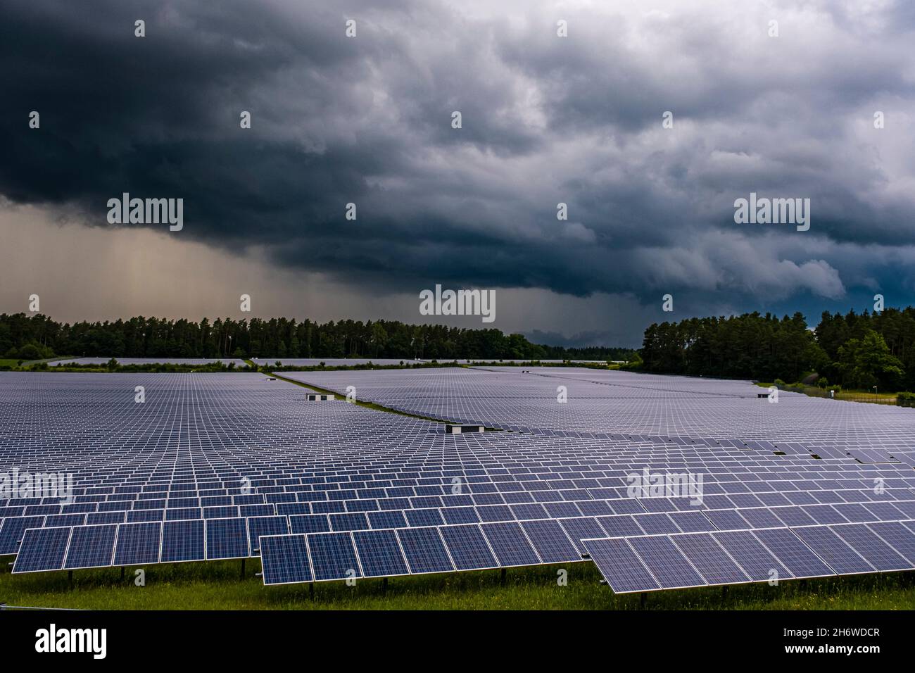 Dark thunderstorm and rain clouds over a big solar powerplant. Stock Photo