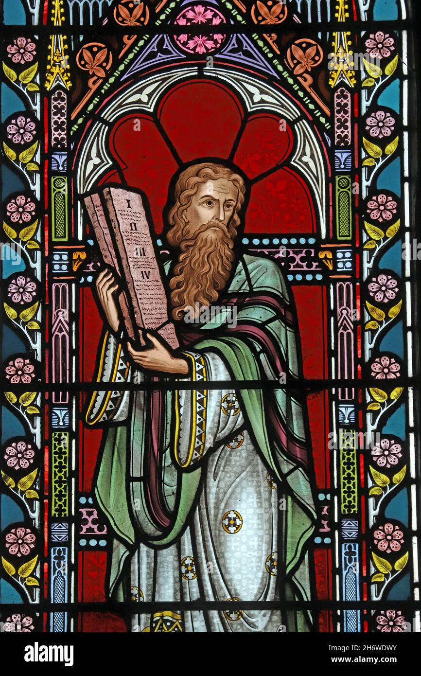 A stained glass window by Frederick Preedy depicting Moses holding the Ten Commandments, St Lawrence Church, Weston-Sub-Edge, Gloucestershire Stock Photo