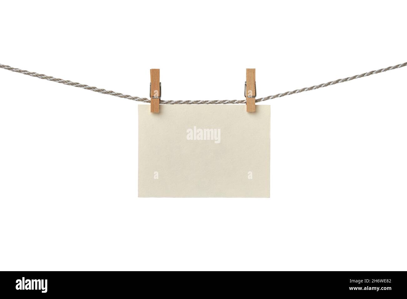 Old paper blank card hanging on the clothesline isolated on white background Stock Photo