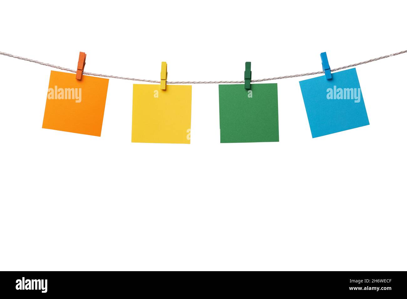 Four multicolored paper blank notes hanging on the rope with wooden ...