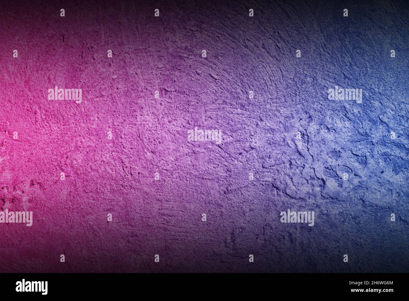 Black rough concrete wall background with neon lights and glowing lights. Lighting effect pink purple and blue on empty cement wall. Stock Photo