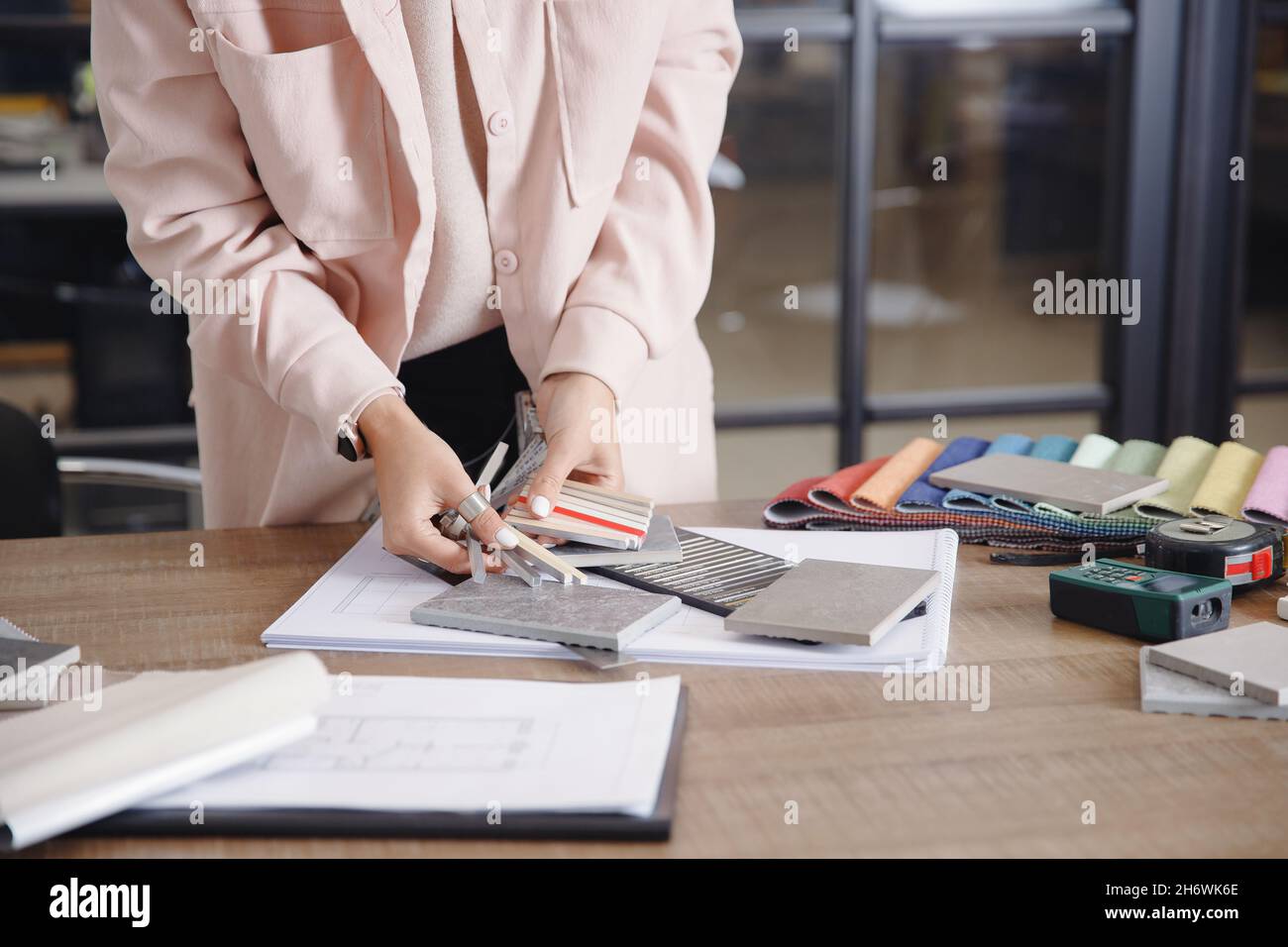 Woman interior designer chooses grout color for ceramic tiles. Stock Photo