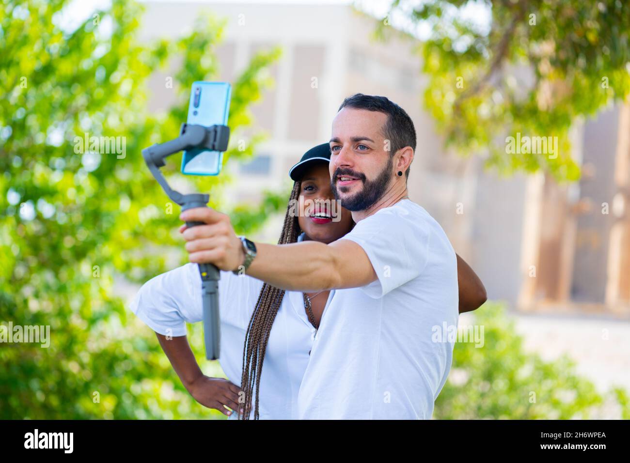 two friends of different ethnicities taking a selfie with the mobile Stock Photo