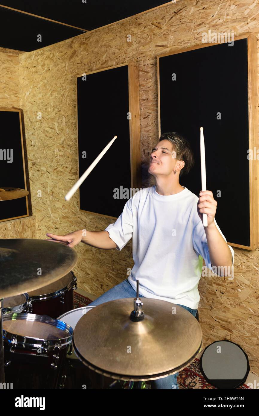 Musician artist beating rhythm is rehearsing behind drum kit. Male
