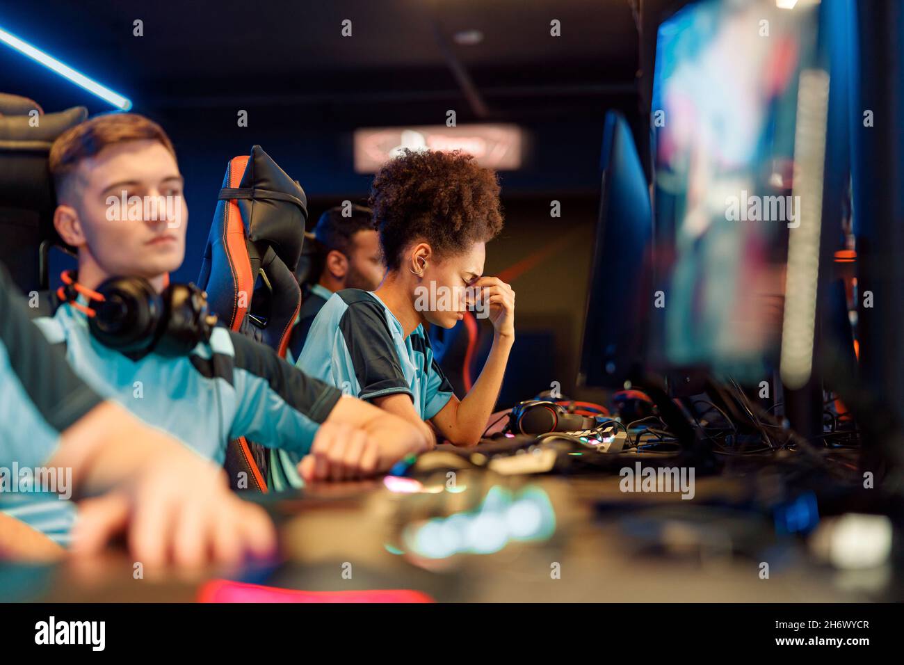 Young woman gamer feeling depressed while playing in cyber club Stock Photo