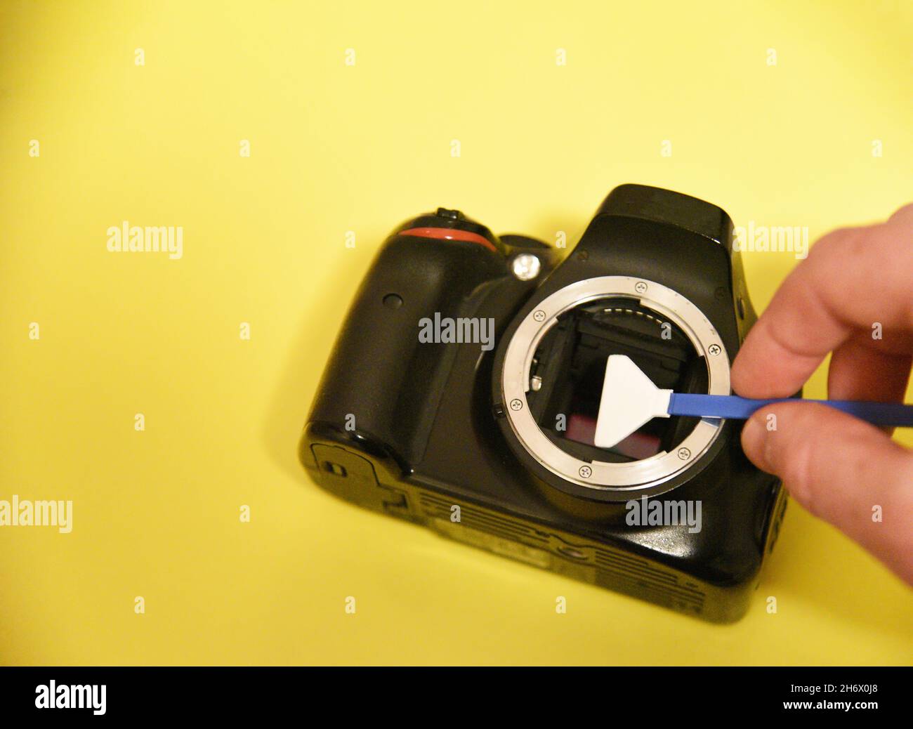Photographer cleaning photocamera light sensor. Cleaning matrix SLR