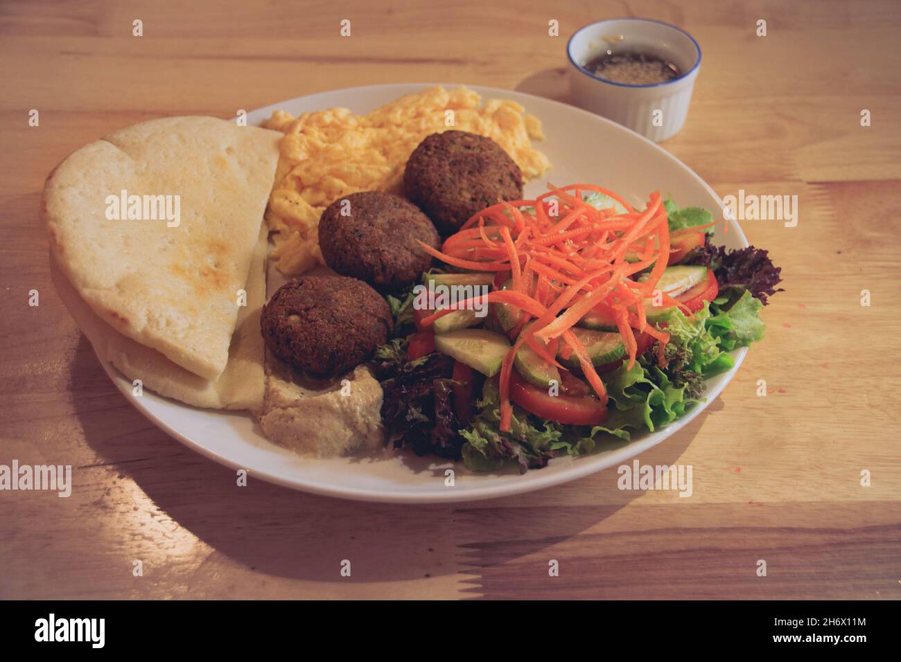 Pita bread, falafel, hummus, salad and scrambled eggs for a healthy