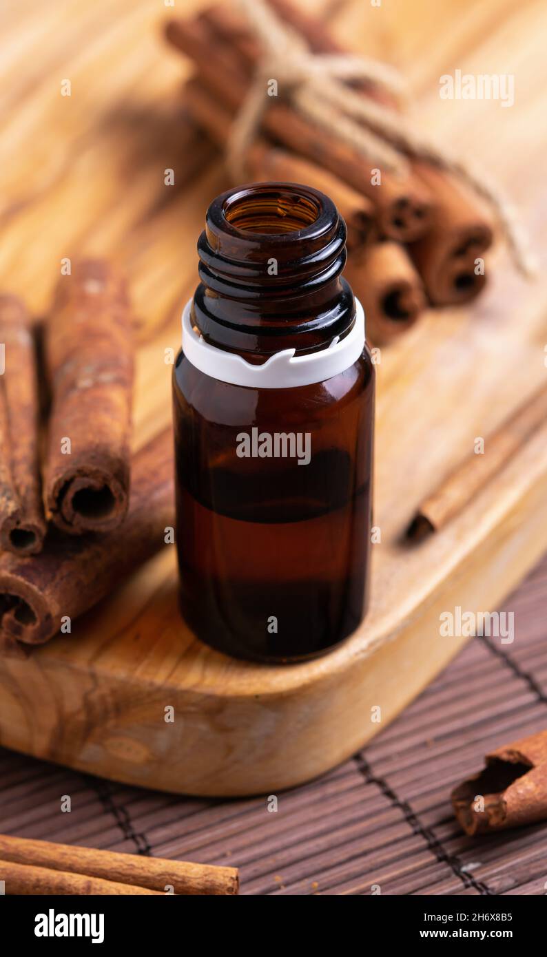 concept of natural cosmetics, glass bottle with oil, cinnamon sticks Stock Photo