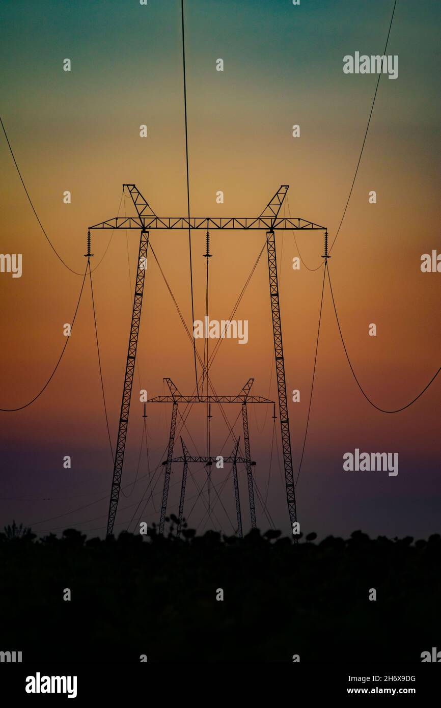 Silhouettes of transmission towers at sunset Stock Photo - Alamy