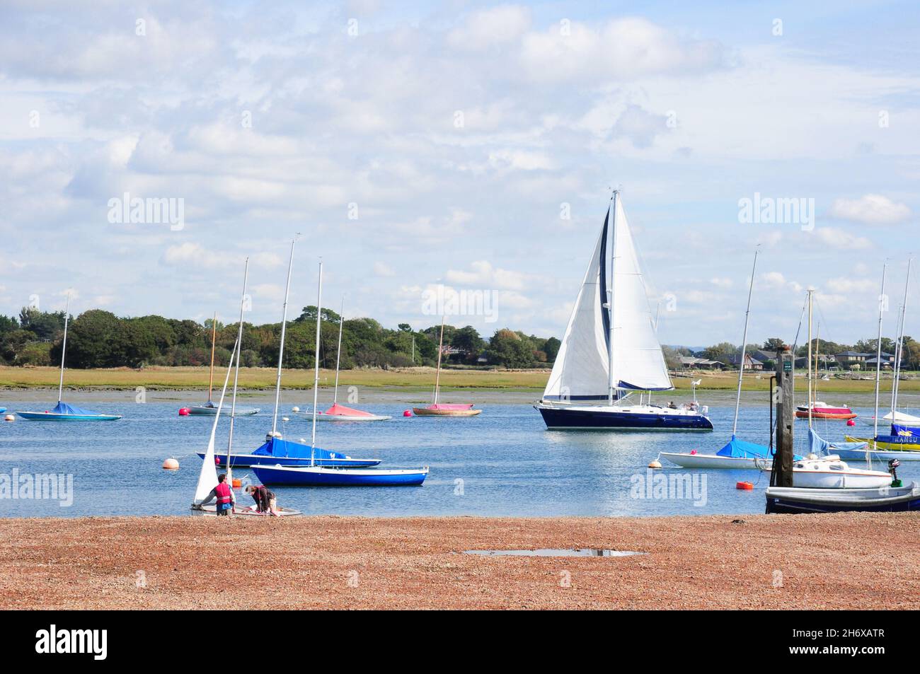 Yacht, and dinghies at Itchenor, West Sussex. Stock Photo