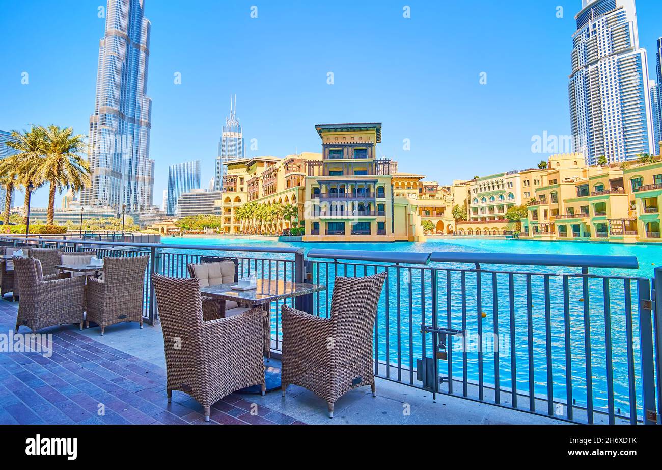The pleasant dinner on the embankment of Burj Khalifa Lake with a view on iconic Burj Khalifa tower and Old Town Island complex in Arabic style, Dubai Stock Photo